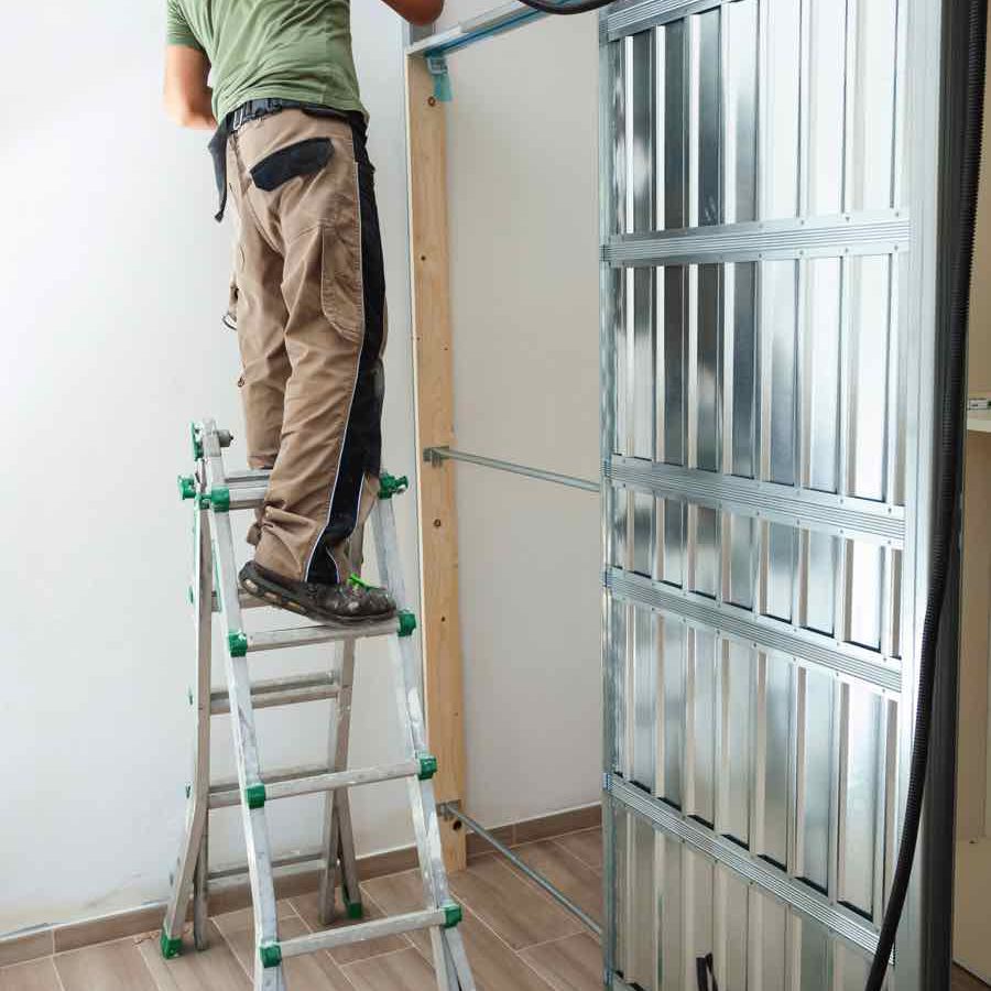 worker-building-plasterboard-wall-N23Z8QU.jpg